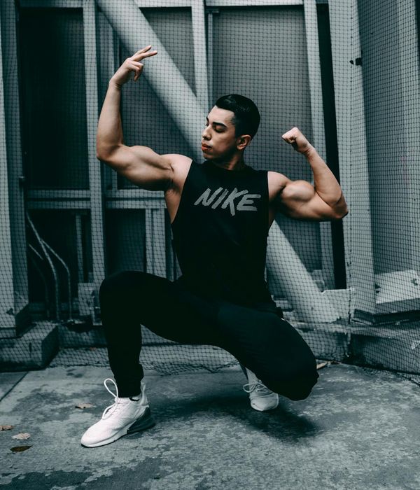 Man performing a controlled strength exercise in a modern gym.